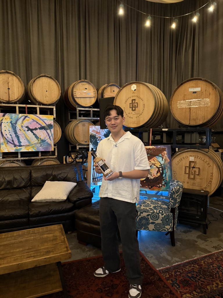 Brandon Hoang at the distillery holding a bottle of Boba After Hours